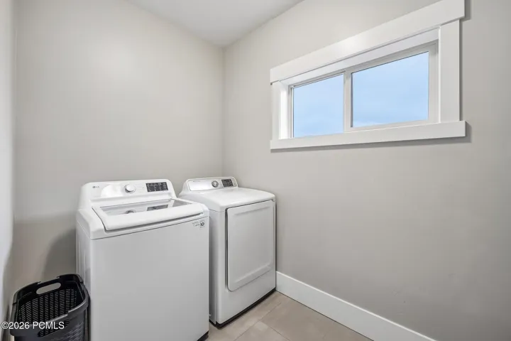 Upstairs laundry room with a side-by-side washer and dryer and folding space, located on the bedroom level.