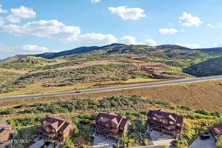 Aerial from the south showing the home against open hillside with the Highway 40 corridor below, about twenty minutes to Park City.