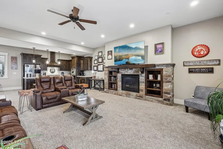 Wide-angle view of the main level showing the stone fireplace, kitchen and dining area in one open floor plan in a Rustler at Hideout home.