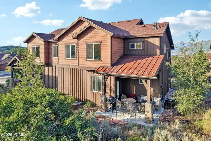 Front elevation with cedar siding, metal roof accents and established low-maintenance landscaping in Rustler at Hideout, Hideout, Utah.