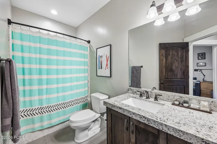 Upstairs full bathroom with a tub-shower combo, granite vanity and shared access from both guest bedrooms.