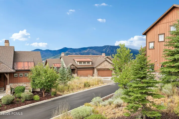 Street view from Viewside Circle of a Rustler at Hideout home with cedar and stone siding and the Wasatch Back behind it.