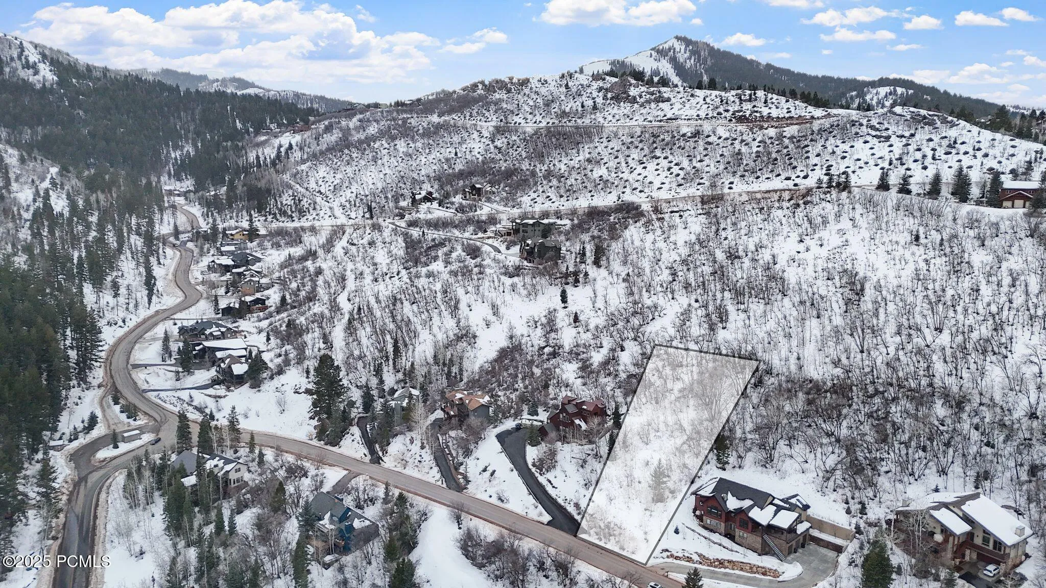 Winter aerial showing the homesite against the Pinebrook ridgeline, with approximate lot lines outlined and plowed, year-round access. Buyer to verify boundaries.