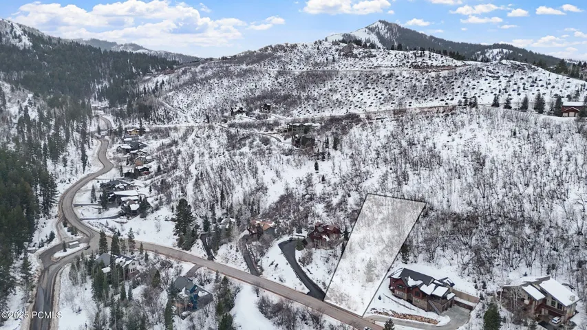 Winter aerial showing the homesite against the Pinebrook ridgeline, with approximate lot lines outlined and plowed, year-round access. Buyer to verify boundaries.