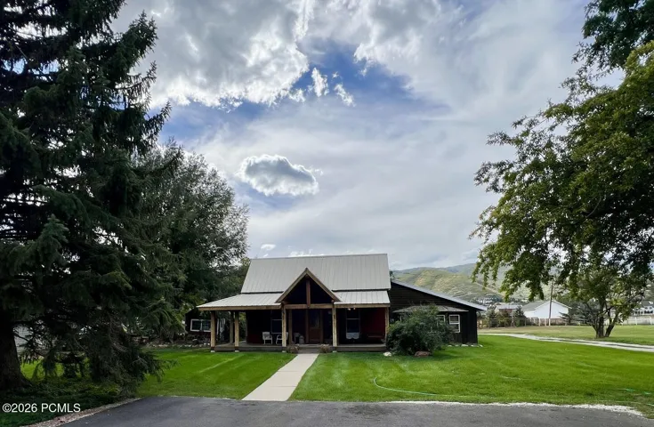 A-frame entry with covered front porch, dark-stained wood siding, and a metal roof