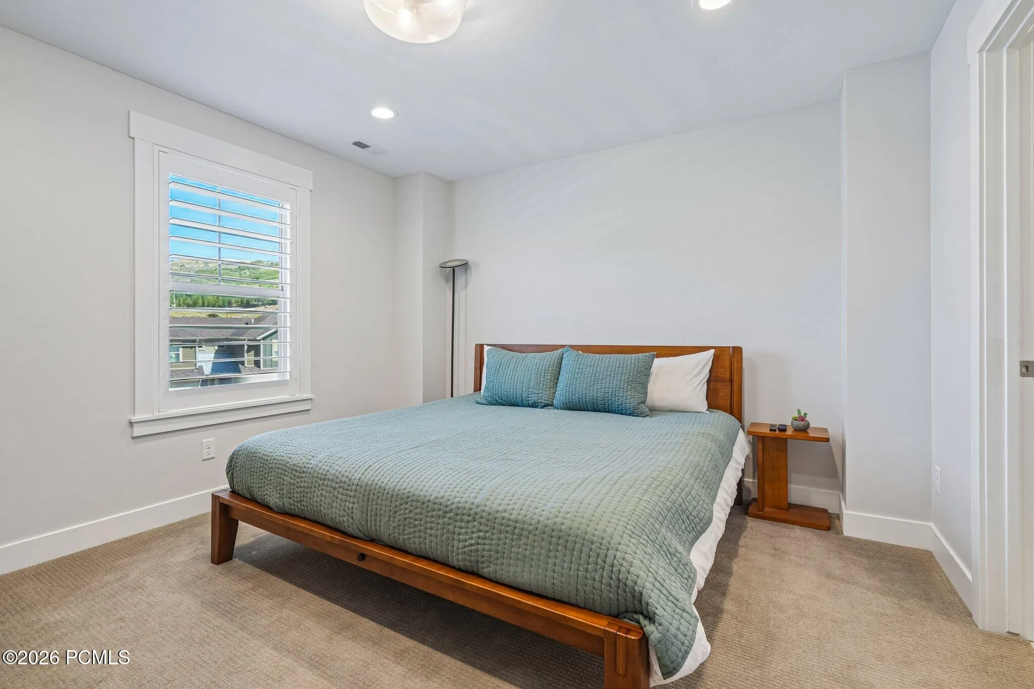 Bedroom with carpet, window, and closet.