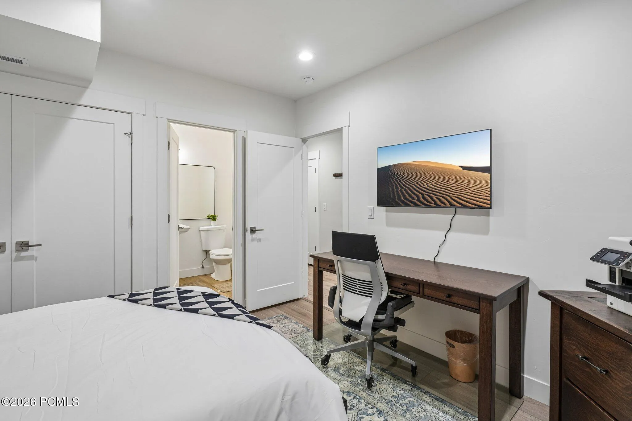 Bedroom with adjacent bath access and space for a desk.