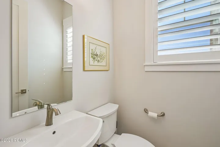 Main-level powder bath with pedestal sink and window.