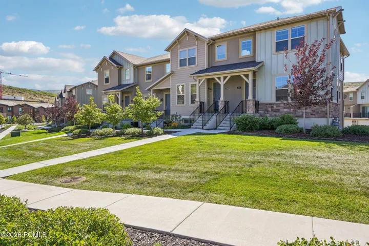 Front exterior with lawn and mature landscaping.