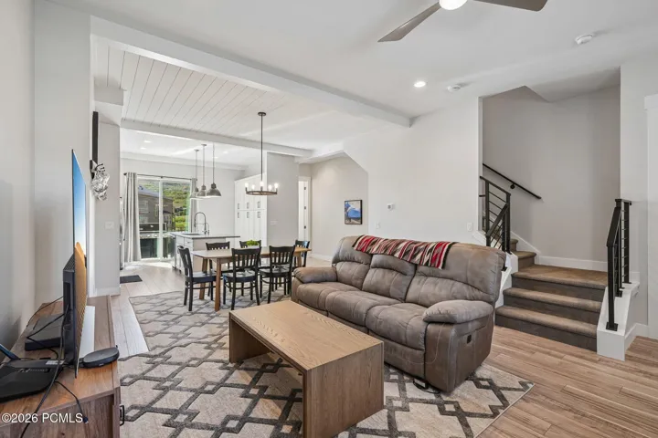 Open main-level living area with wood-look flooring and stairs to the upper and lower levels.