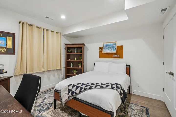Bedroom with carpet, window, and room for a desk.
