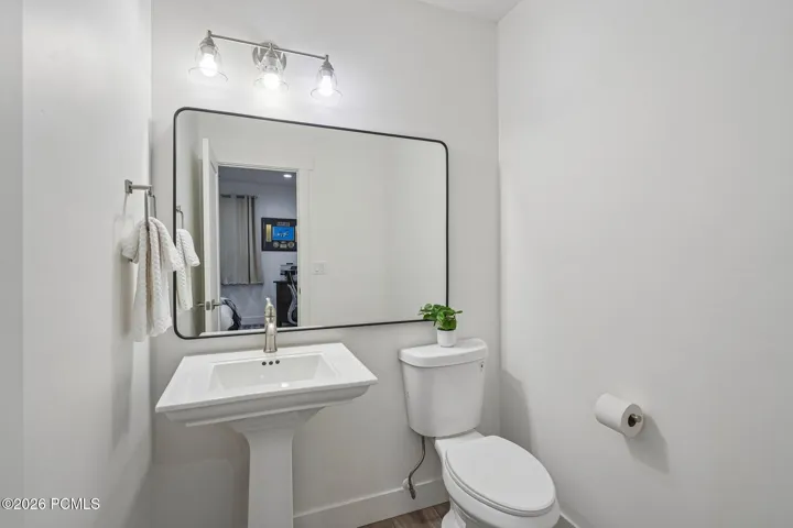 Guest bath with pedestal sink and framed mirror.