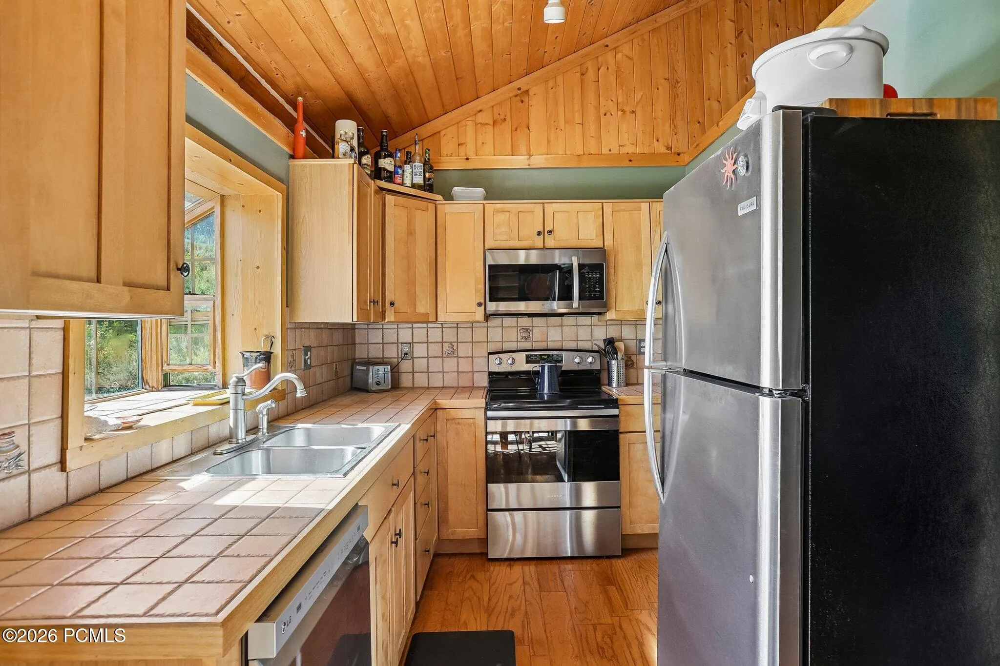 Tile countertoTile countertops, stainless appliances, and a window above the sink. A genuine working kitchen for people who cook after a day on the trails.