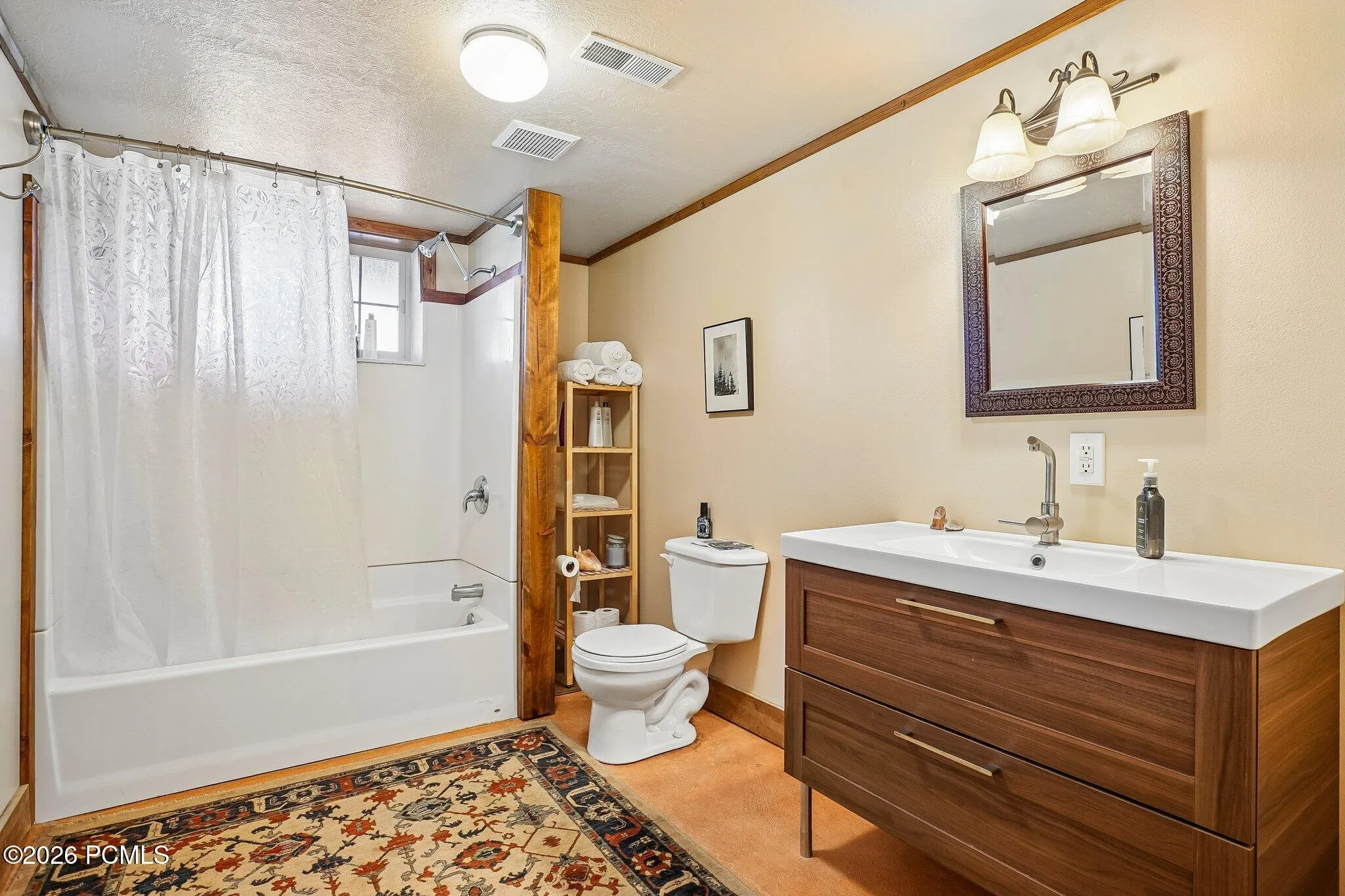 A lower-level full bath with a tub and shower combination, a wood vanity, and a framed mirror, keeping the downstairs fully self-sufficient.A lower-level full bath with a tub and shower combination, a wood vanity, and a framed mirror, keeping the downstairs fully self-sufficient.Lower-level full bathroom with a tub and shower combination, a wood vanity with a rectangular sink, and a framed mirror.