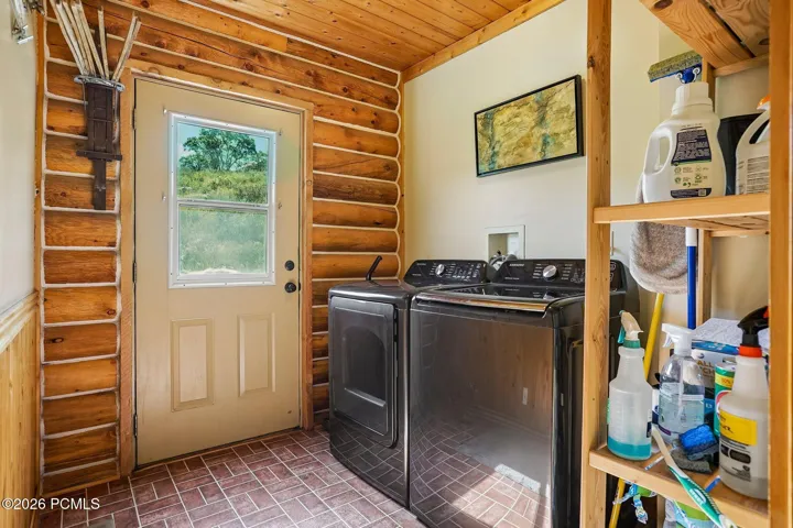 Laundry and mud room open off the side door, exactly where they belong when everyone comes in wet from the snow.Laundry and mud room open off the side door, exactly where they belong when everyone comes in wet from the snow.Main-level laundry and mud room with a washer and dryer, storage shelving, and an exterior door to the side yard.
