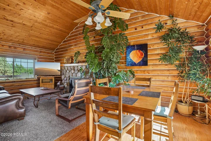 Living Living and dining run together beneath a ceiling fan, with windows on two sides so the main level stays open and bright even when the weather turns.