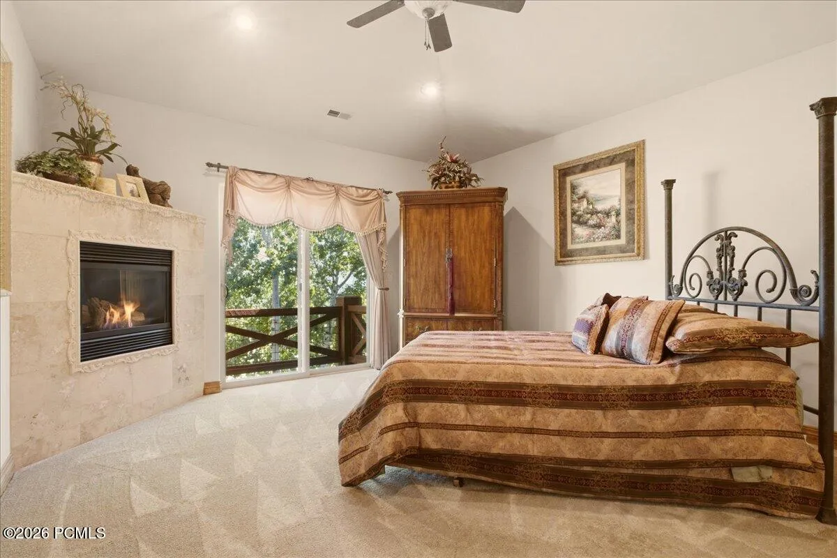 Owner's suite featuring a built-in fireplace, and a balcony with wooden railings