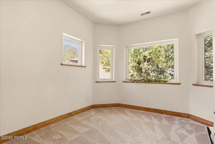 Bedroom/office featuring multiple windows with wood-finish sills