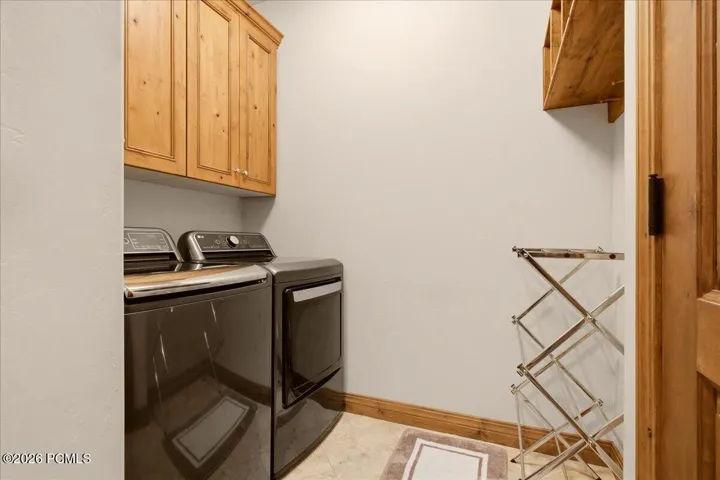 Wood cabinetry, wood door, tiled flooring, wood trim