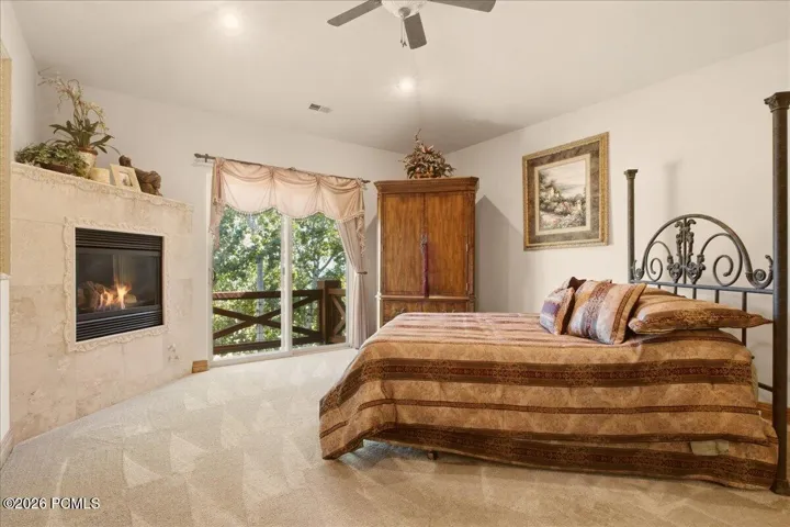 Owner's suite featuring a built-in fireplace, and a balcony with wooden railings
