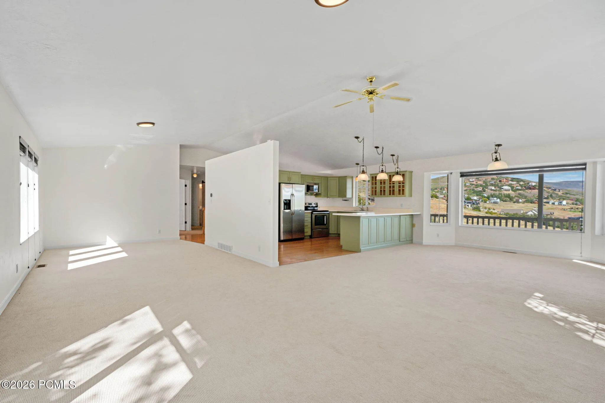 Open-concept living area with carpeting, recessed lighting, and a ceiling fan