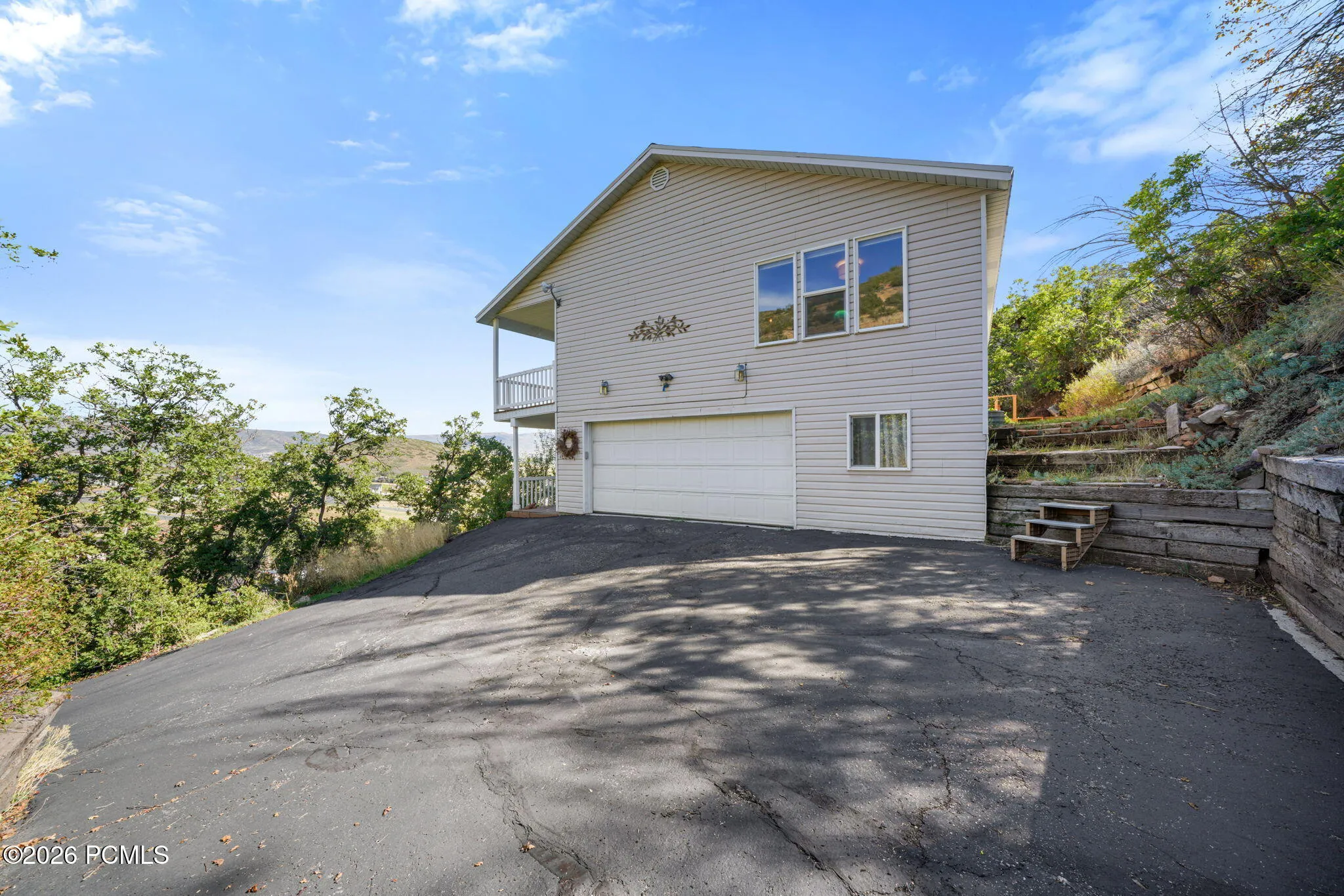 Two-story exterior with horizontal siding, an integrated two-car garage, and a second-story balcony