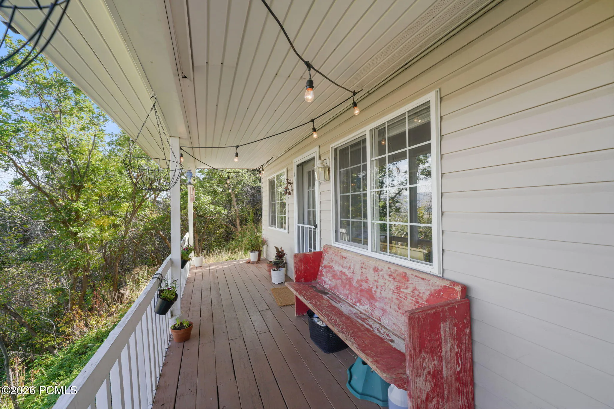 Covered porch with wood-finish flooring, white railing