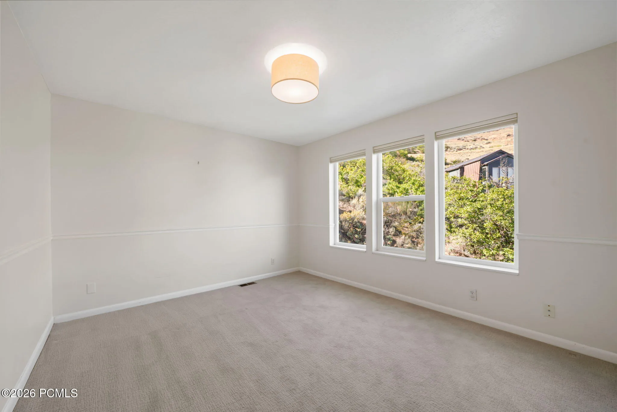 Master Bedroom: Light-filled room featuring a vaulted ceiling, recessed lighting, and three large windows