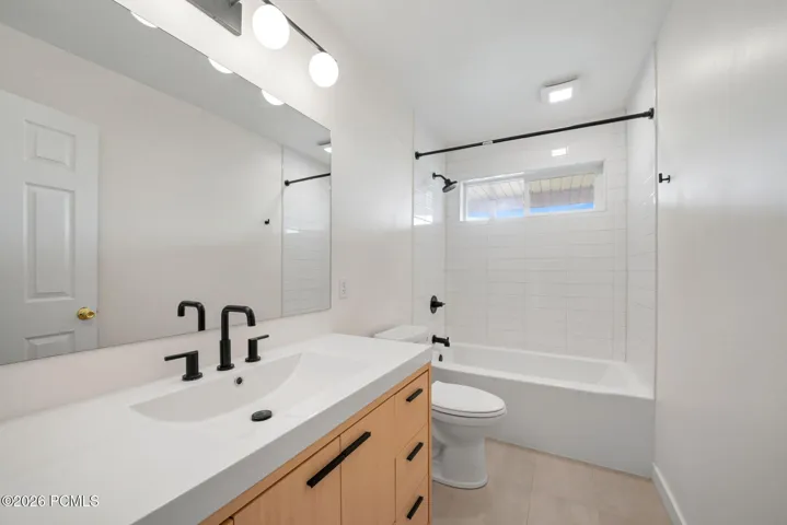 Wood-finish vanity with a white countertop and integrated sink