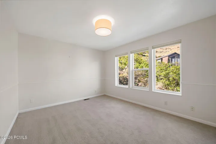 Master Bedroom: Light-filled room featuring a vaulted ceiling, recessed lighting, and three large windows