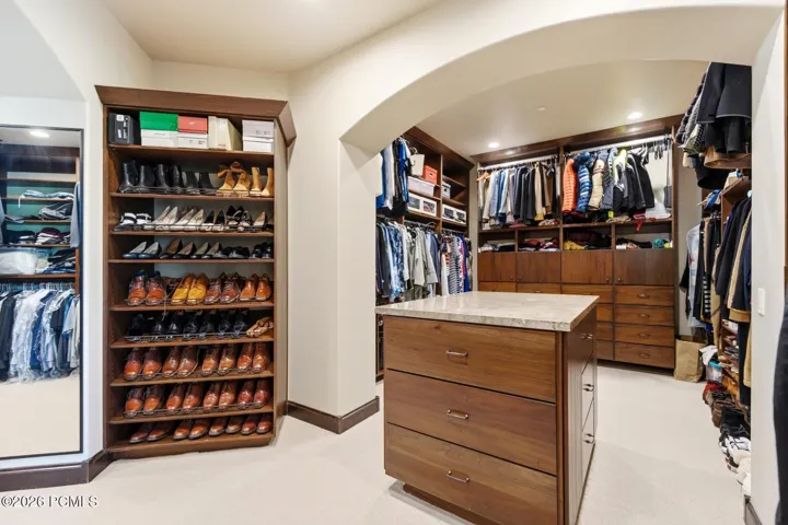 Enormous and refined Primary Closet with built in cabinetry.