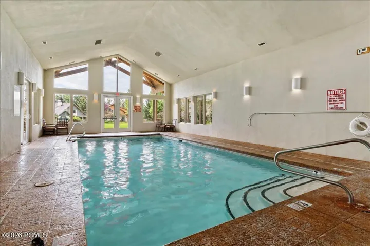 Community indoor pool featuring vaulted ceilings