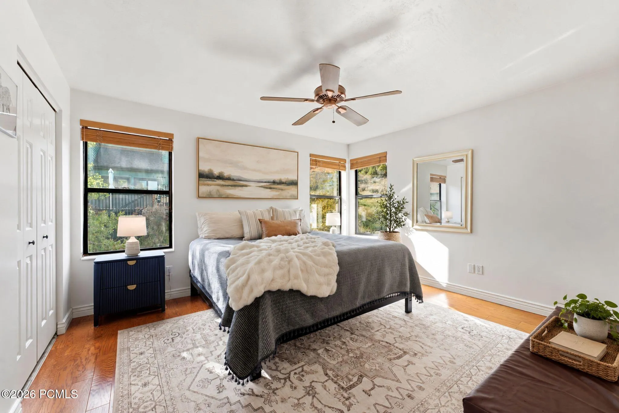 A bank of windows fills the primary bedroom with morning light.