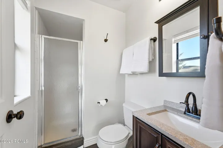 Primary bath with walk-in glass shower and tile floors.