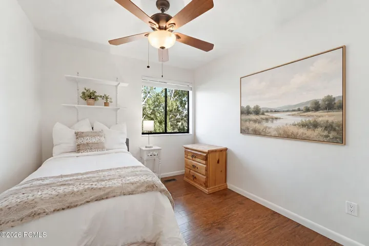 Bright bedroom with ceiling fan, overlooking the aspens.