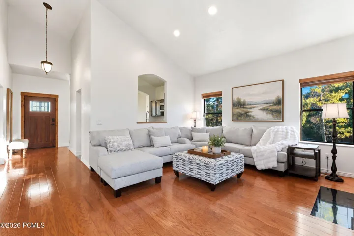 Sectional seating framed by a pair of windows, with natural light all day. Virtually staged.