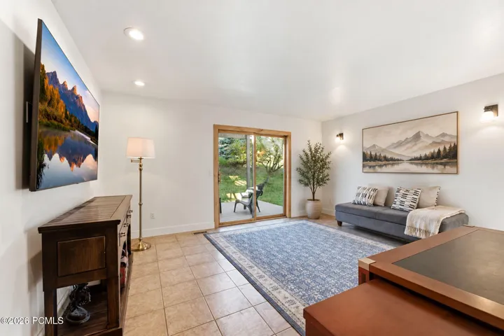 Lower-level family room | Office | 4th Bedroom with a wall-mounted TV and space to spread out.