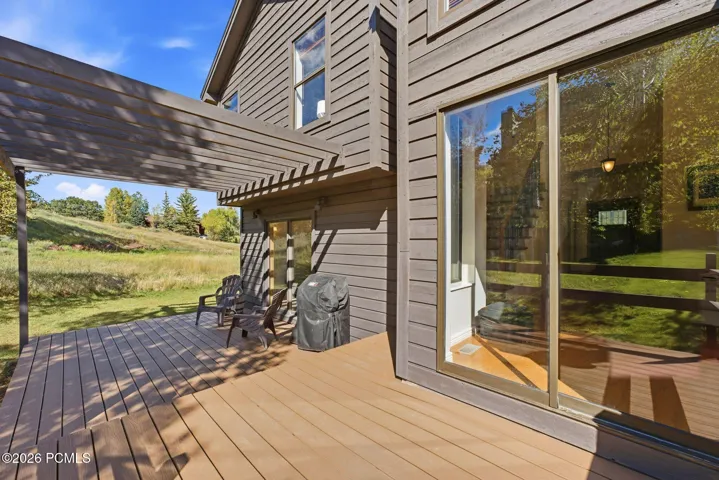 Backyard backs onto open space, framed by mature aspens.