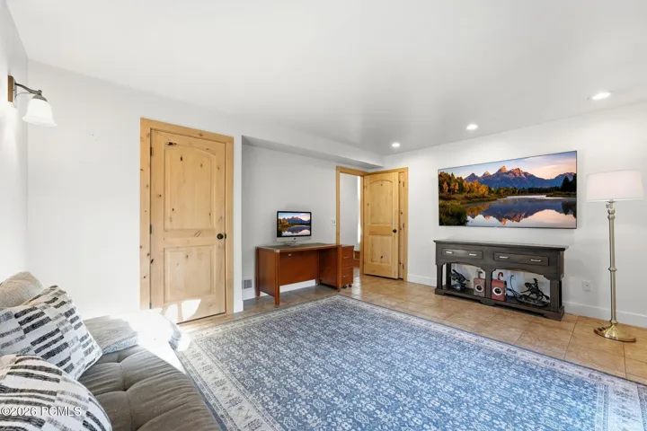 Lower-level family room with a wall-mounted TV and space to spread out.