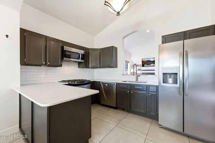 Kitchen with quartz counters, white subway tile and stainless appliances.