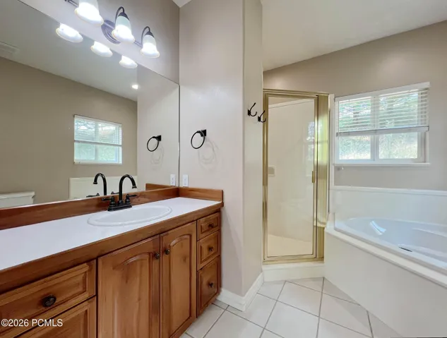 Primary en-suite bathroom w/ corner garden tub & separate shower