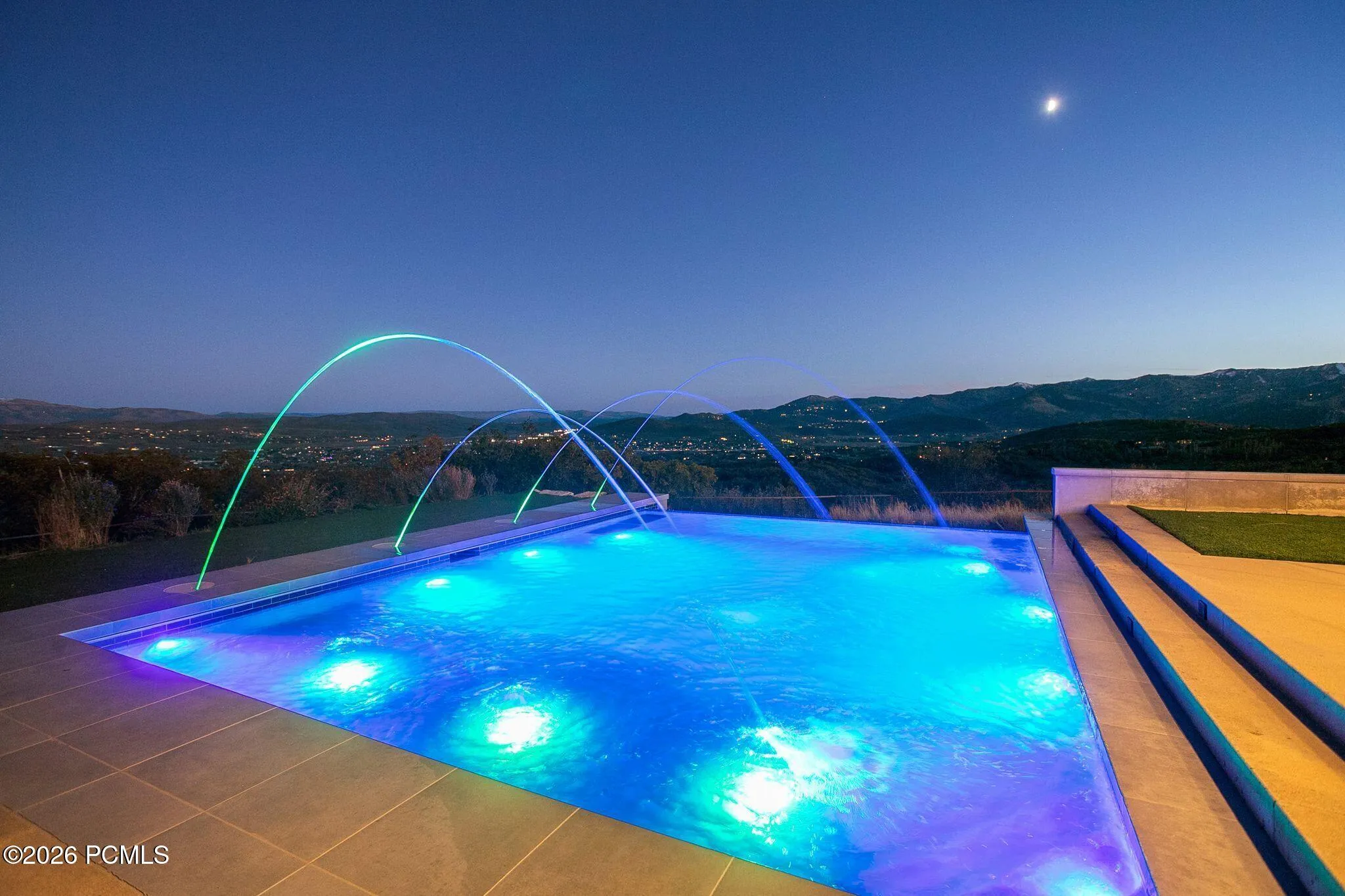 Majestic patio with infinity-edge swimming pool and water features, covered terrace and Park City Mountain Views