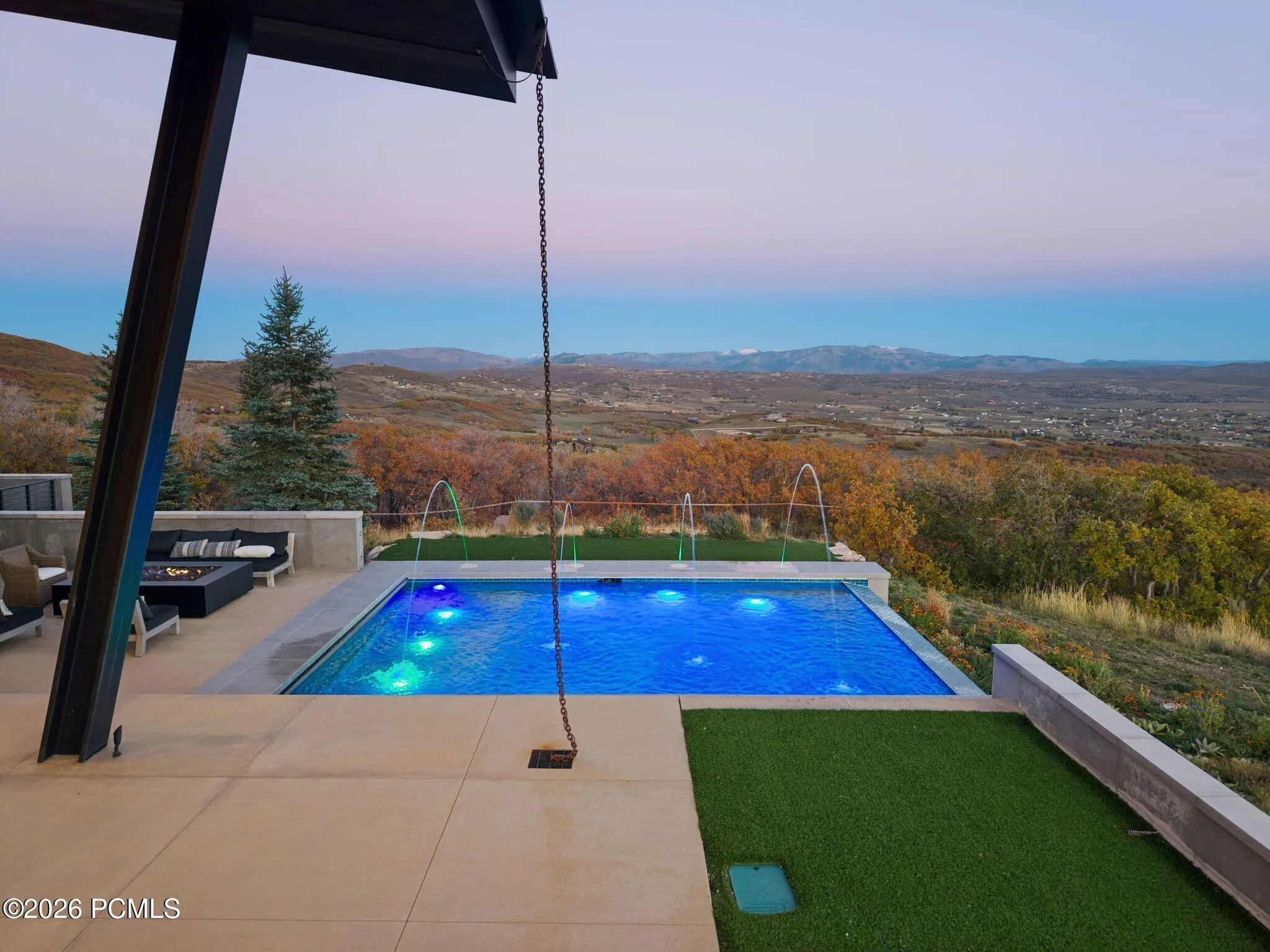 Majestic patio with infinity-edge swimming pool and water features, covered terrace and Park City Mountain Views