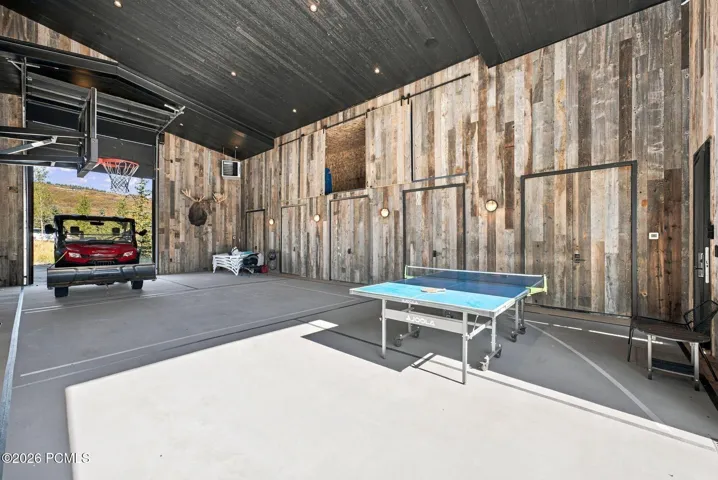 Detached recreation barn (~41' x 32') provides indoor pickleball and basketball courts. Oversized drive through roll-up doors provide convenient RV or boat storage. Upper and lower storage areas for all your outdoor equipment