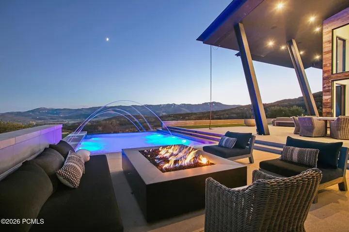 Majestic patio with infinity-edge swimming pool and water features, covered terrace and Park City Mountain Views