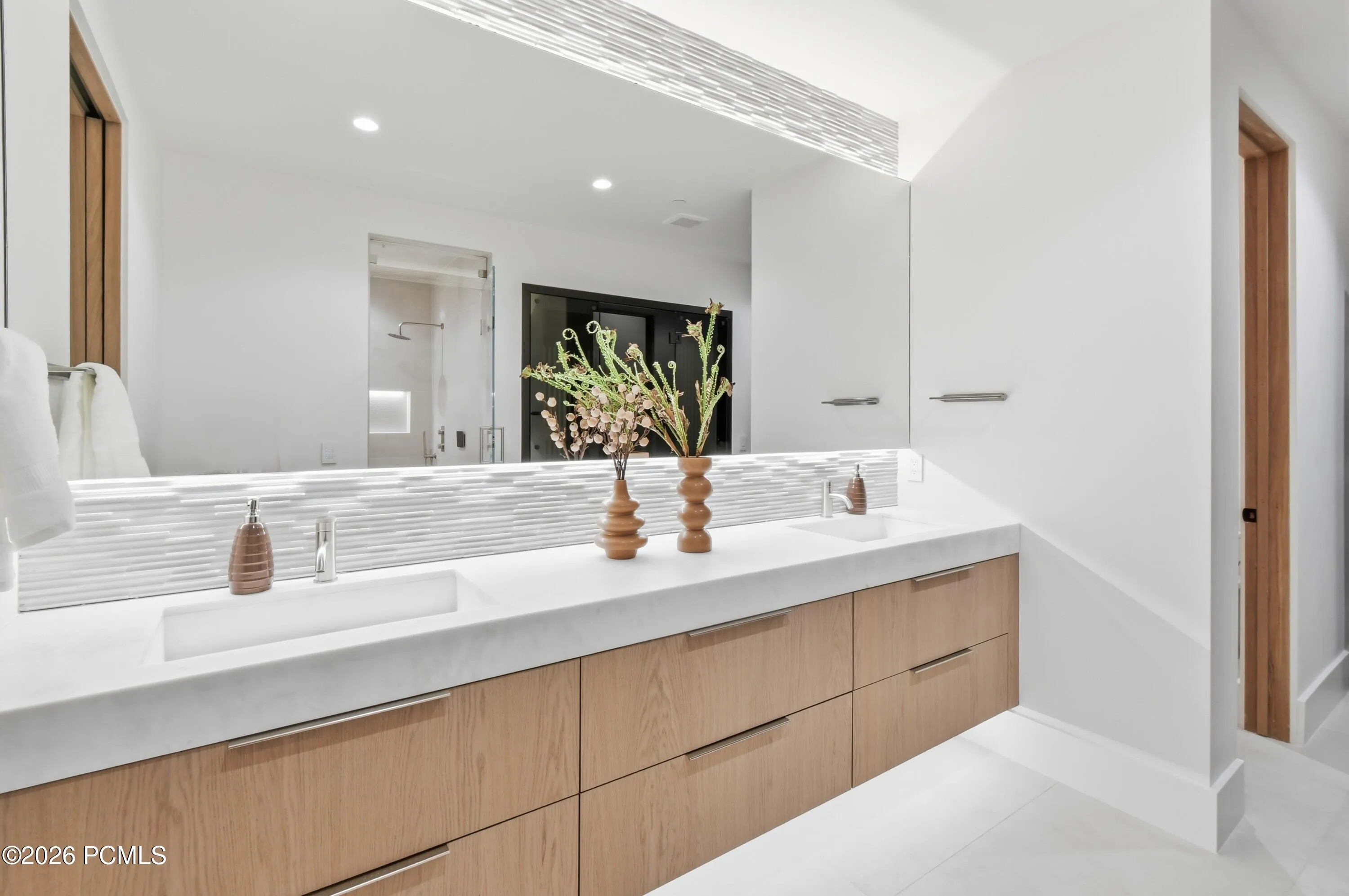 A personal beauty atelier awaits, where dual vanities & LED-backlit mirrors cast a flattering radiance for every skincare ritual. A soft ribbon of light beneath the cabinetry lends the room an intimate, candlelit quality, while radiant-heated floors greet bare feet with enveloping warmth. Generous vanity drawers accommodate a curated collection of serums, creams, facial masks & treasured beauty essentials, transforming the daily glow-up into an indulgent ritual of self-care.
