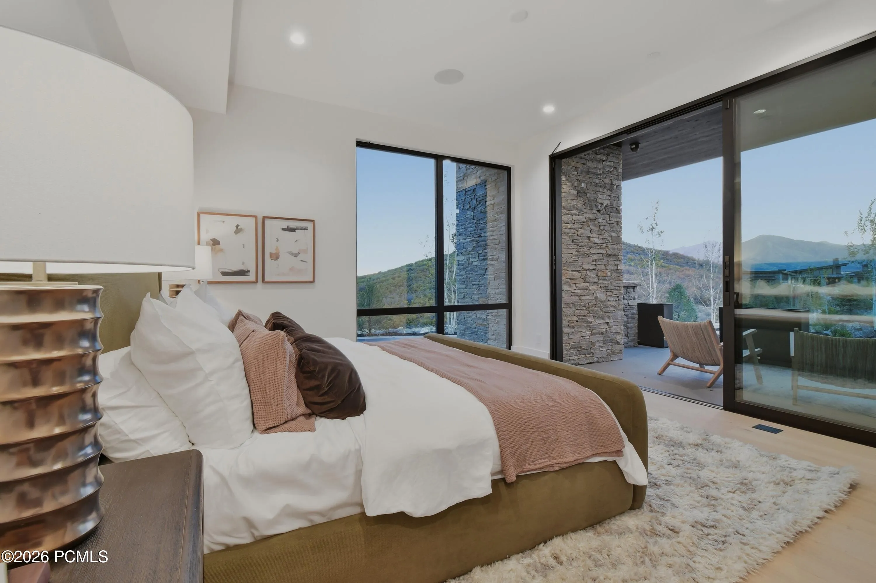 Expansive walls of glass bathe the interior in an exquisite balance of natural light, while the serene mountain landscape beyond introduces a calming connection to nature. The interplay of luminous interiors, sweeping views & earthy surroundings creates an atmosphere of effortless elegance, where the beauty of the outdoors becomes an integral part of the room’s character.