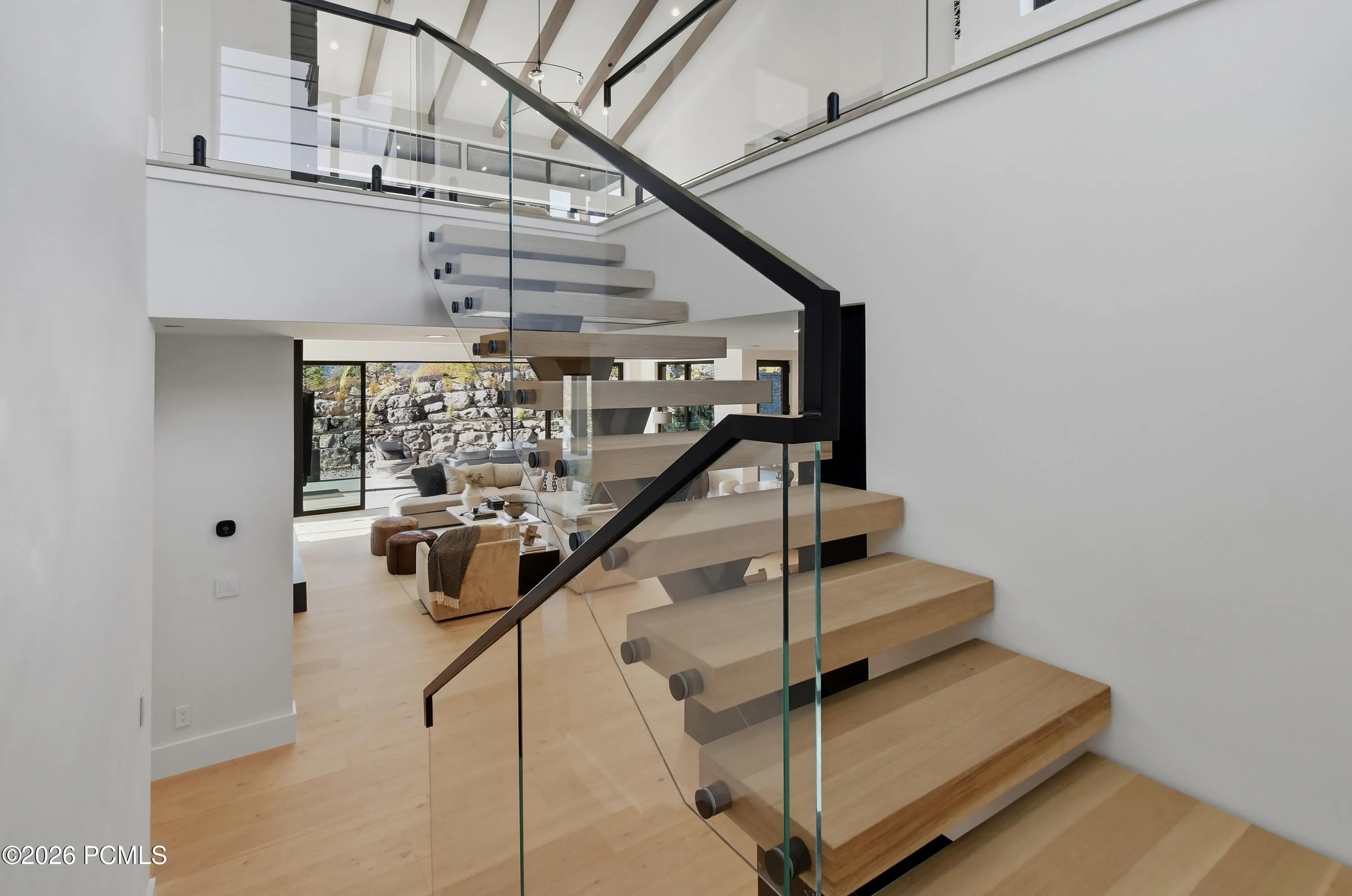 An extraordinary floating staircase enclosed in glass creates a breathtaking architectural statement, transforming the journey to the lower level into an experience of elevated design. An artful interplay of transparency, light & architectural precision lends the space a captivating sense of movement, where even the transition between floors becomes a defining expression of the home’s distinctive character.