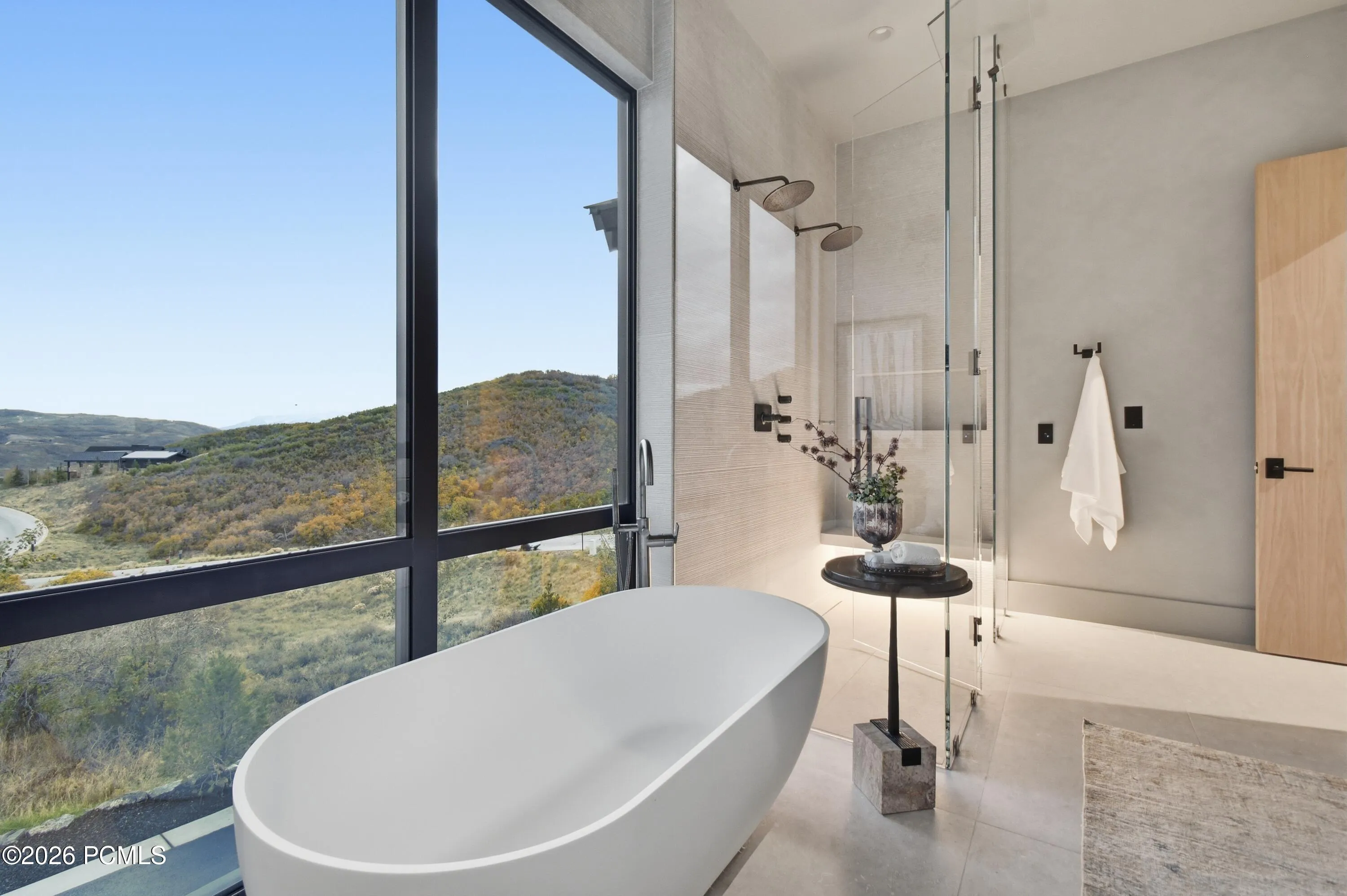 Immerse yourself in the serenity of a freestanding soaking tub, where expansive windows frame the natural beauty beyond, transforming every bath into a restorative escape. Prewired for automated window treatments, this intimate sanctuary allows you to personalize privacy & natural light to suit every moment.