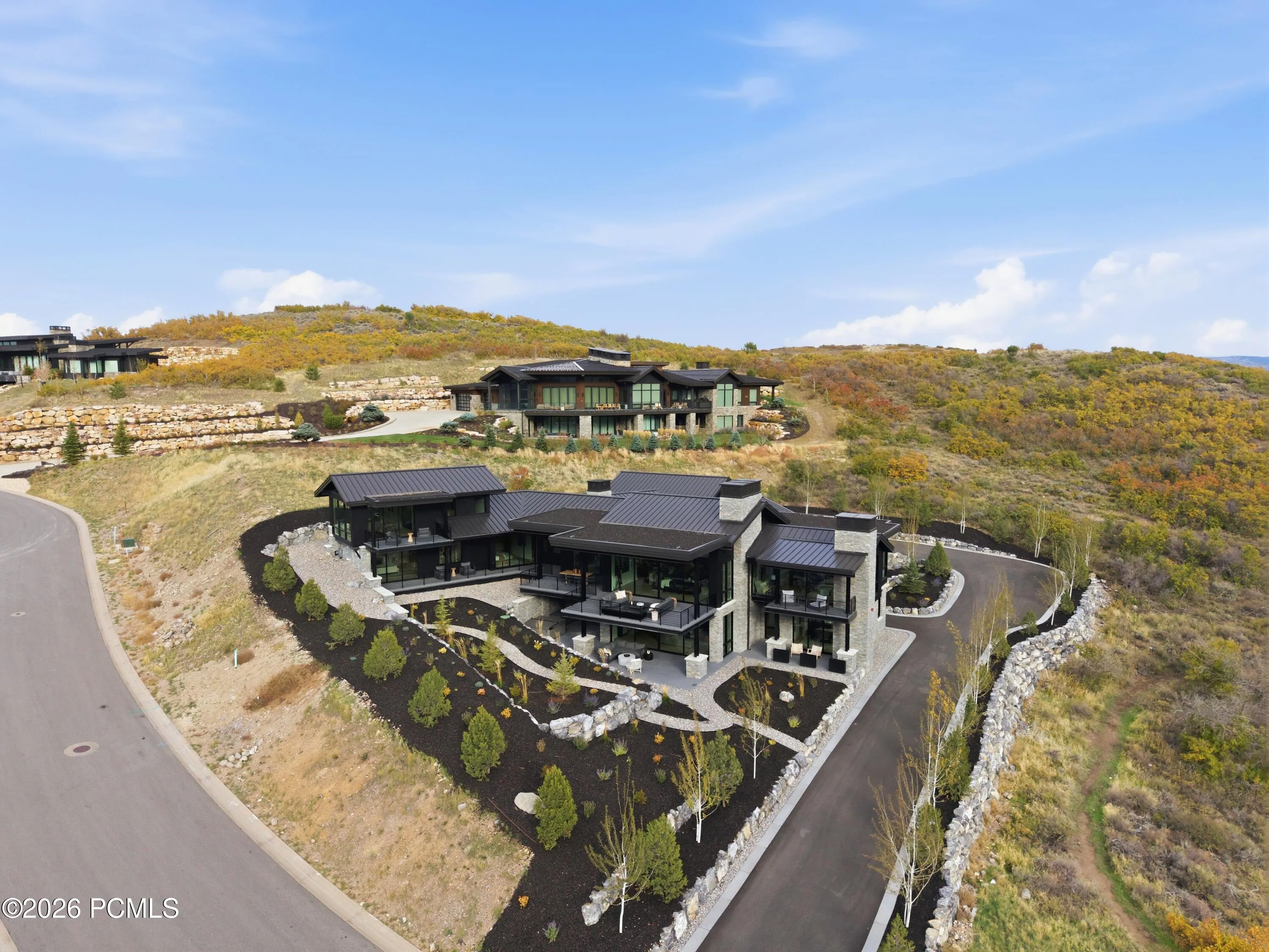 Bathed in natural daylight, the home makes a distinguished first impression with its substantial driveway, elegantly finished curbing & impressive stone retaining walls defining the property. The broad approach creates a sense of openness & arrival, while the rugged character of the rockwork lends a timeless, grounded quality to the setting. A compelling balance of polished infrastructure & authentic mountain character, reflecting the caliber of this exceptional property.